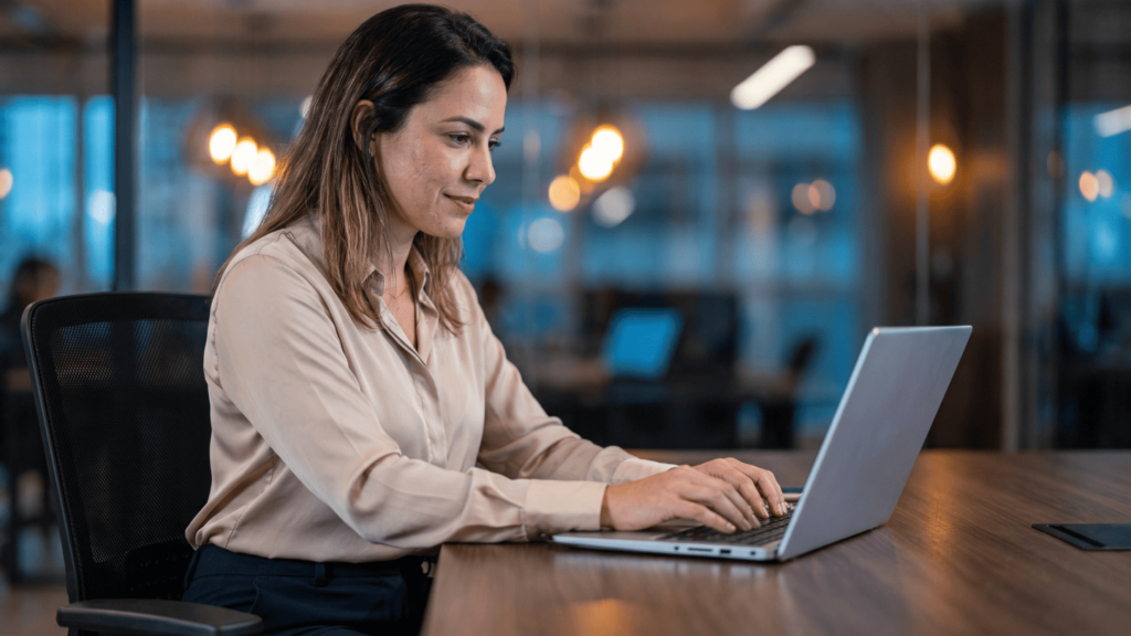 Profissional utiliza software ERP em notebook para adequar a gestão tributária da empresa às exigências da reforma tributária.