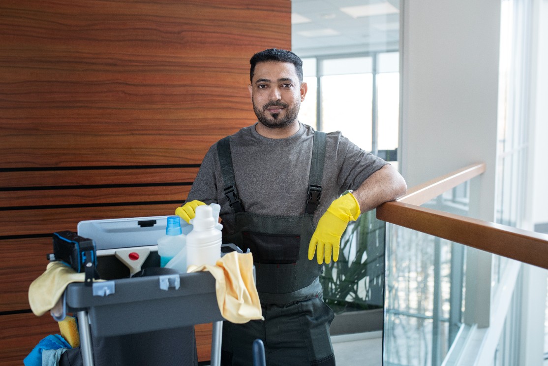 Imagem de um homem trabalhando com carrinho de limpeza