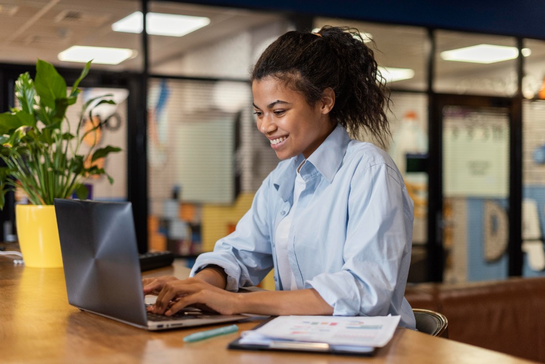 Mulher sorridente trabalhando com laptop no escritório