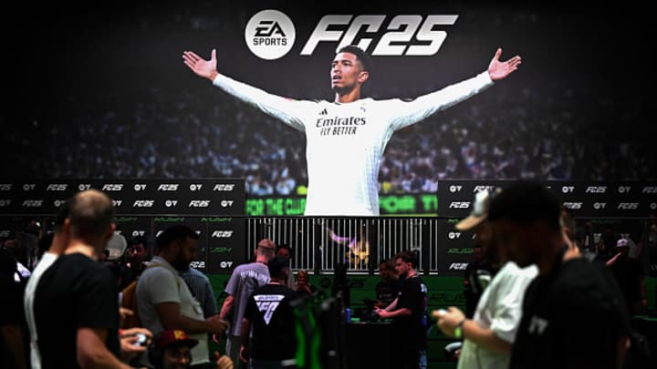 Visitantes jogam o jogo EA Sports FC 25 em frente a um cartaz com o meio-campista da Inglaterra, Jude Bellingham, no estande da Electronic Arts durante o dia da mídia na feira de jogos Gamescom em Colônia, oeste da Alemanha, em 21 de agosto de 2024. (Foto: Ina Fassbender | AFP | Getty Images)