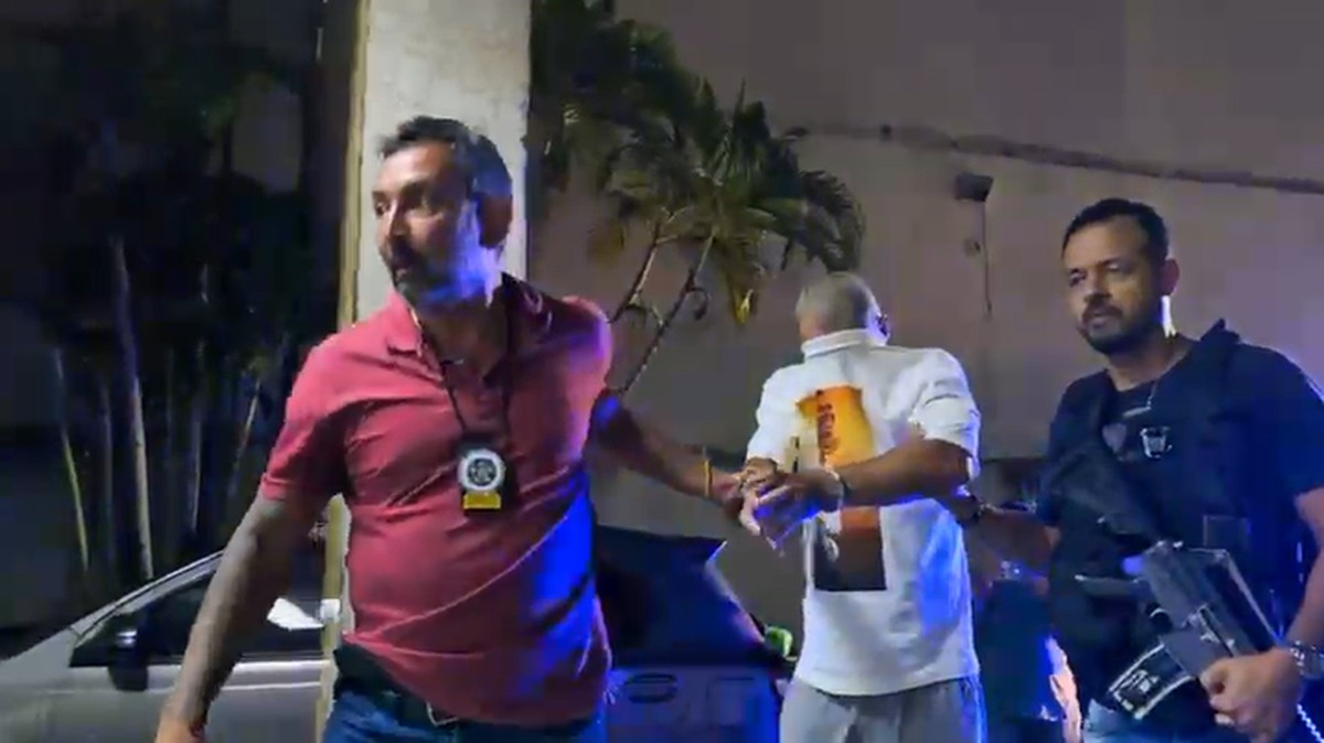 De branco, o homem suspeito de torturar menina de 4 anos é levado por agentes da 37ª DP (Ilha do Governador) (Foto: Divulgação/Polícia Civil)