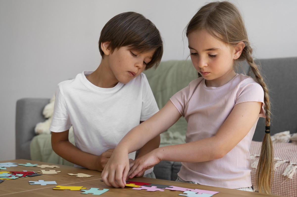 Menino e menina brincam de quebra-cabeça (Foto: Freepik)