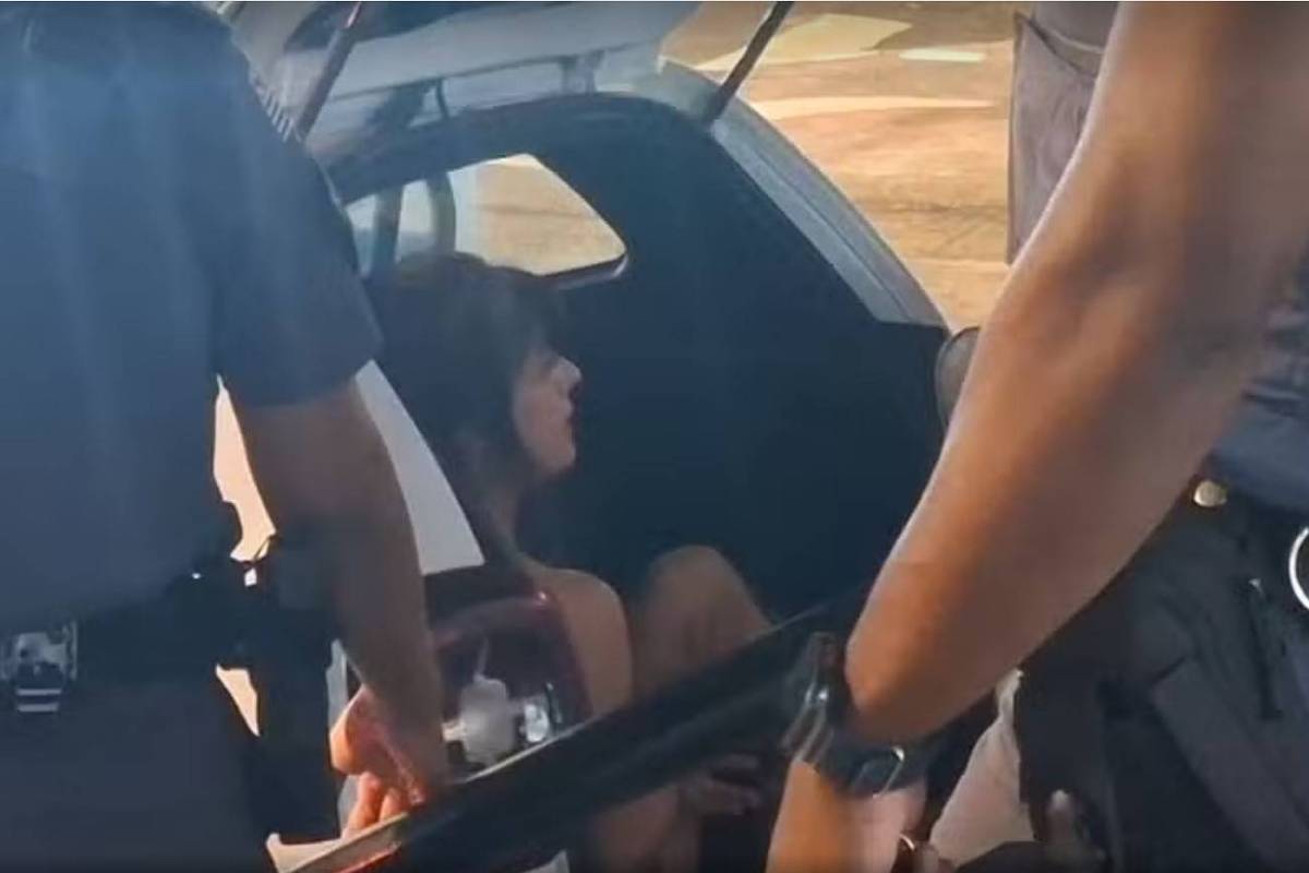 Ex-panicat Ana Paula Leme no carro da PM após ser detida (Foto: Reprodução/TV Globo)