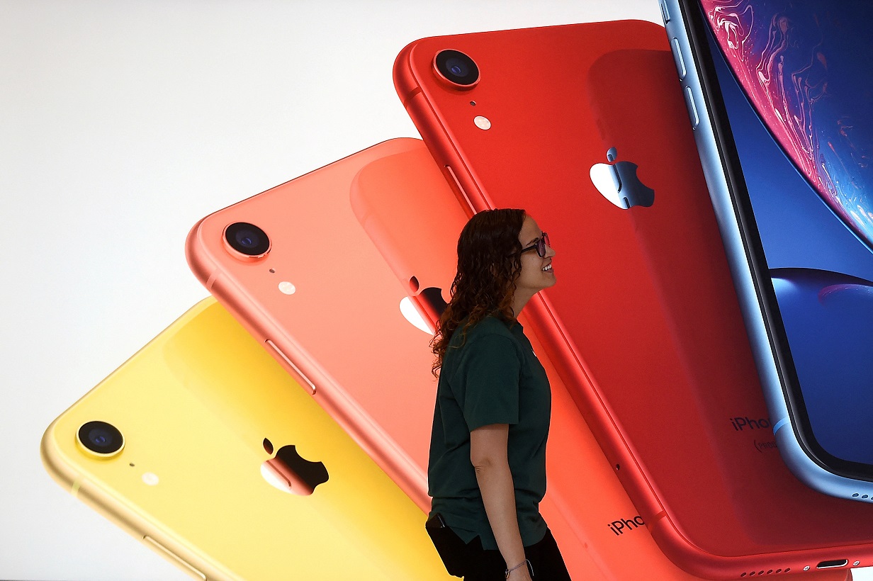 Um funcionário da Apple passa por uma ilustração de iPhones na nova Apple Carnegie Library durante a inauguração e a prévia para a mídia em Washington, EUA, em 9 de maio de 2019. (Foto: REUTERS/Clodagh Kilcoyne/Foto de Arquivo)