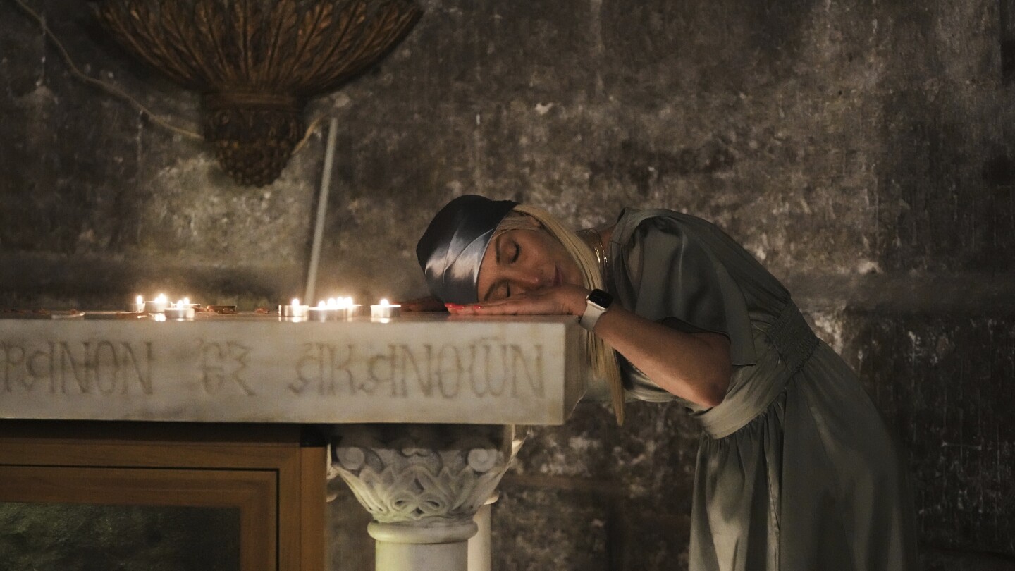 Uma peregrina cristã descansa a cabeça enquanto ora durante a Missa de Páscoa no Domingo de Páscoa na Igreja do Santo Sepulcro, local onde, segundo a tradição, Jesus foi crucificado e sepultado, na Cidade Velha de Jerusalém, domingo, 20 de abril de 2025. (Foto: AP Photo/Mahmoud Illean)