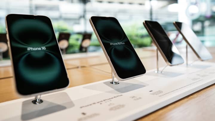 Foto de um funcionário da Apple passando por uma ilustração de iPhones na nova Apple Carnegie Library durante a inauguração e a prévia para a mídia em Washington, EUA, em 9 de maio de 2019. (Foto: REUTERS/Clodagh Kilcoyne/Foto de Arquivo)