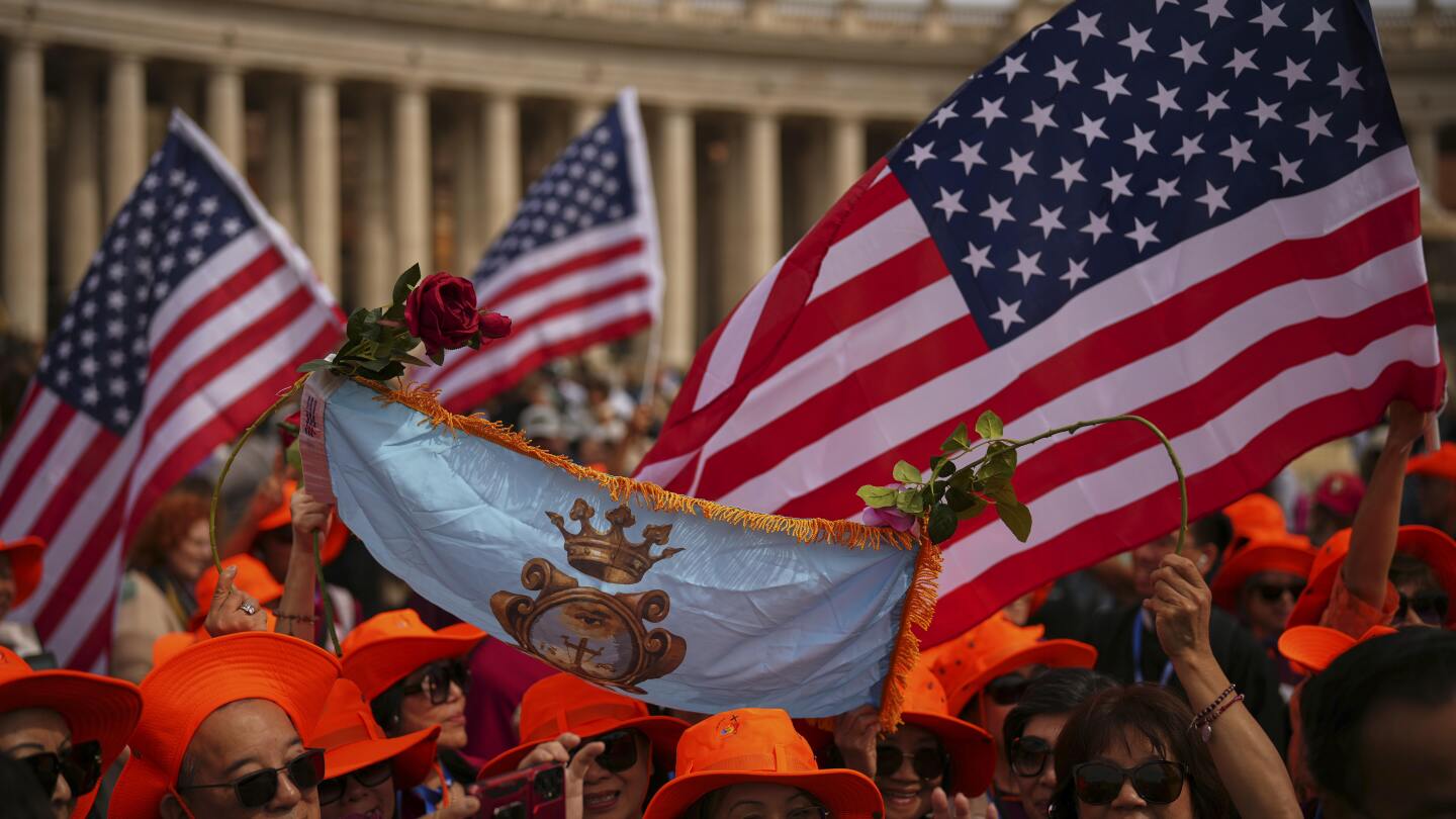 Fiéis agitam bandeiras dos Estados Unidos enquanto aguardam a aparição do Papa Leão XIV na sacada central da Basílica de São Pedro para sua primeira bênção de domingo após sua eleição, na Praça de São Pedro, no Vaticano, no dia 11 de maio de 2025. (Foto: Andrew Medichini/AP)