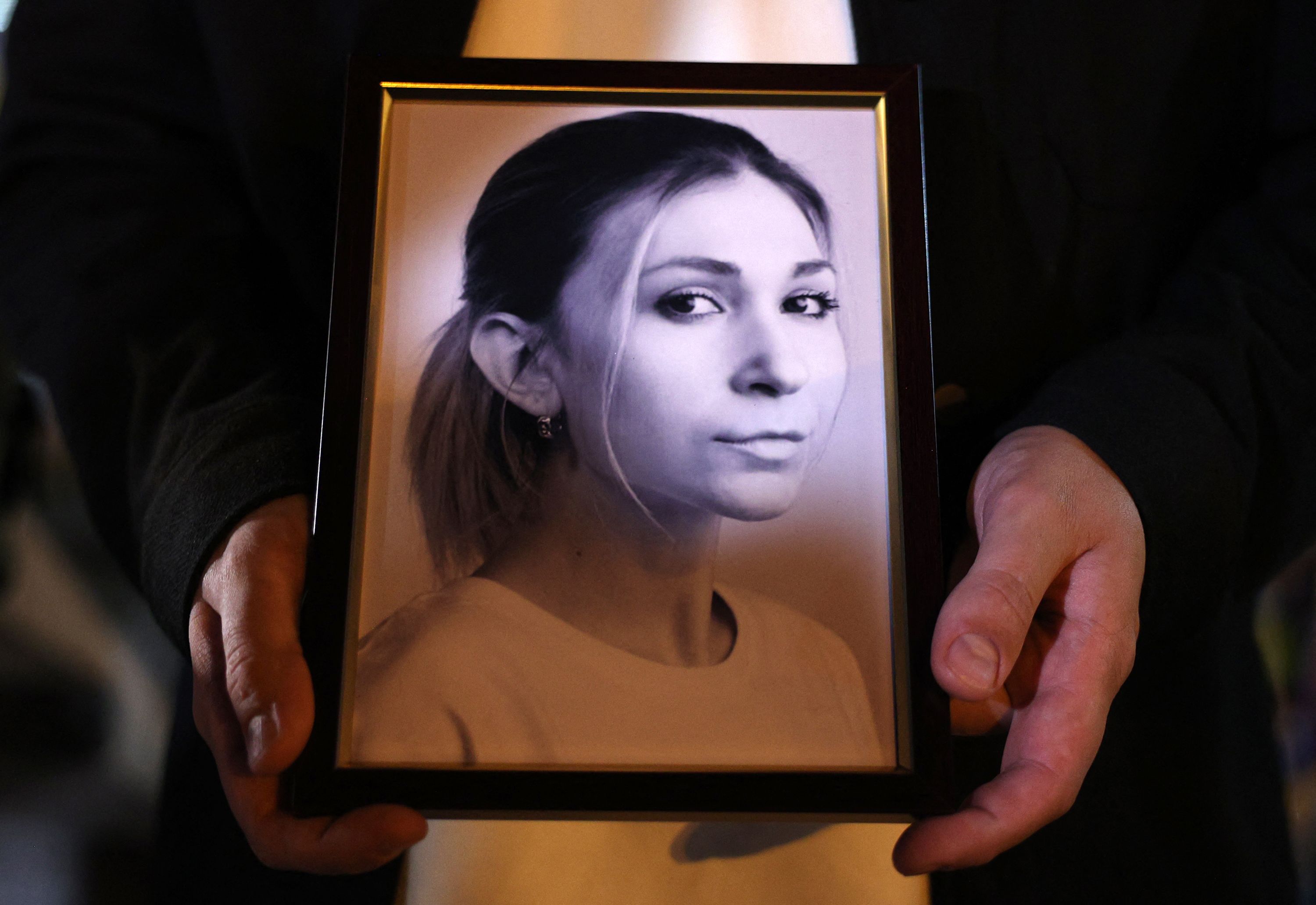 Colega da jornalista Victoria Roshchyna segura foto dela durante memorial em Kiev (Foto: Anatolii STEPANOV / AFP)