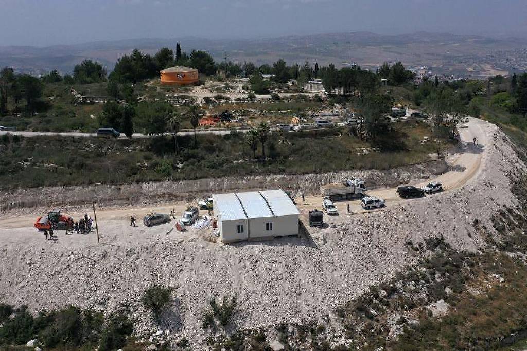Vista aérea mostra pessoas circulando em torno de obra no posto avançado de colonos de Homesh - 29 de maio de 2023. (Foto: AFP)