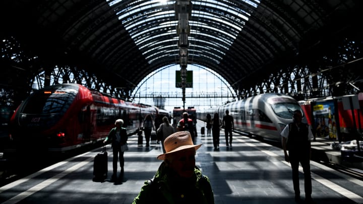 Passageiros caminham em uma plataforma passando por um trem de alta velocidade ICE (InterCity Express) e um trem regional na estação ferroviária principal em Frankfurt am Main, oeste da Alemanha, em 20 de maio de 2025. (Foto: Kirill Kudryavtsev | Afp | Getty Images)