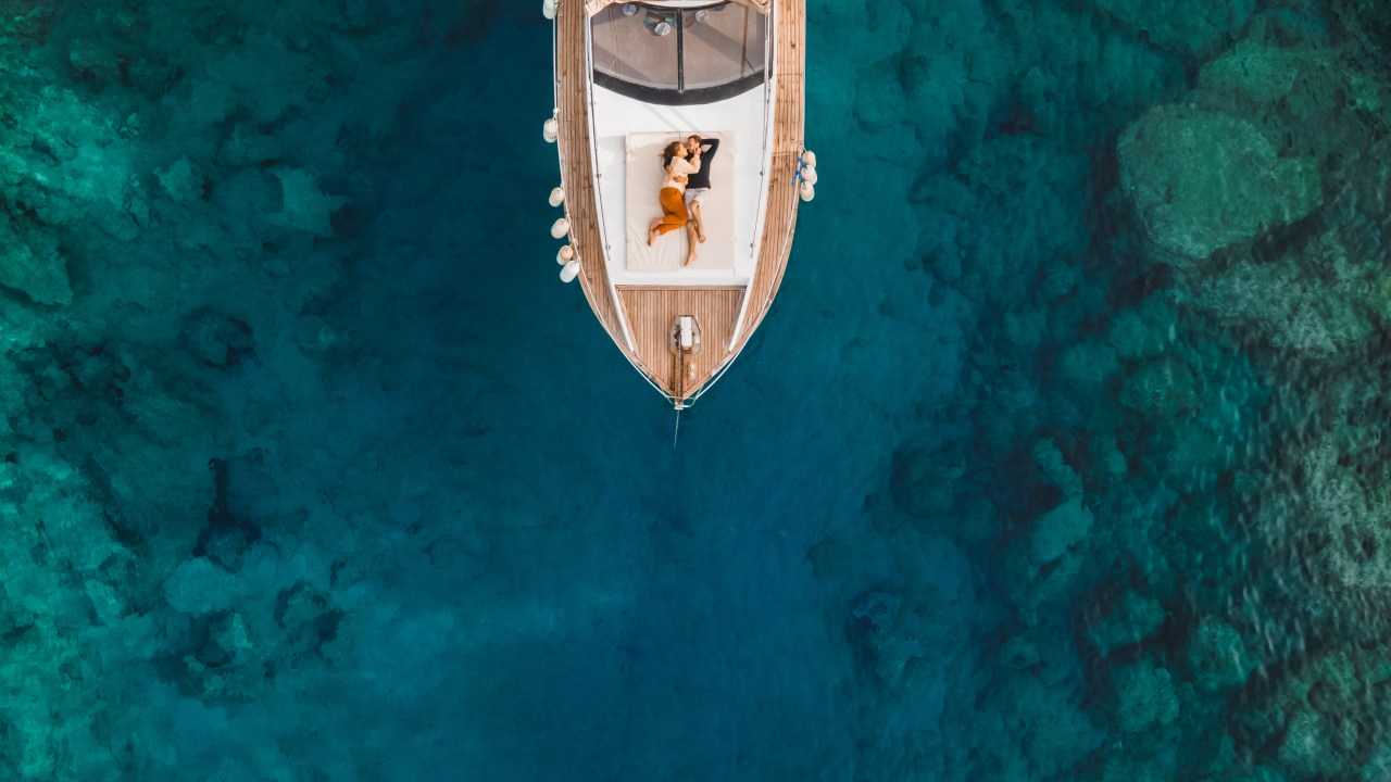 Lua de mel de luxo em cruzeiro. Férias de pessoas ricas. Casal jovem e bem-sucedido viaja e aventura em barco privado. Paisagem marítima dos sonhos e idílica vista de cima. (Foto: Getty Images)