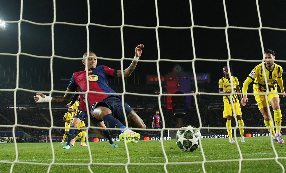 Raphinha completa em cima da linha e abre o placar para o Barcelona contra o Borussia Dortmund (Foto: REUTERS/Albert Gea)