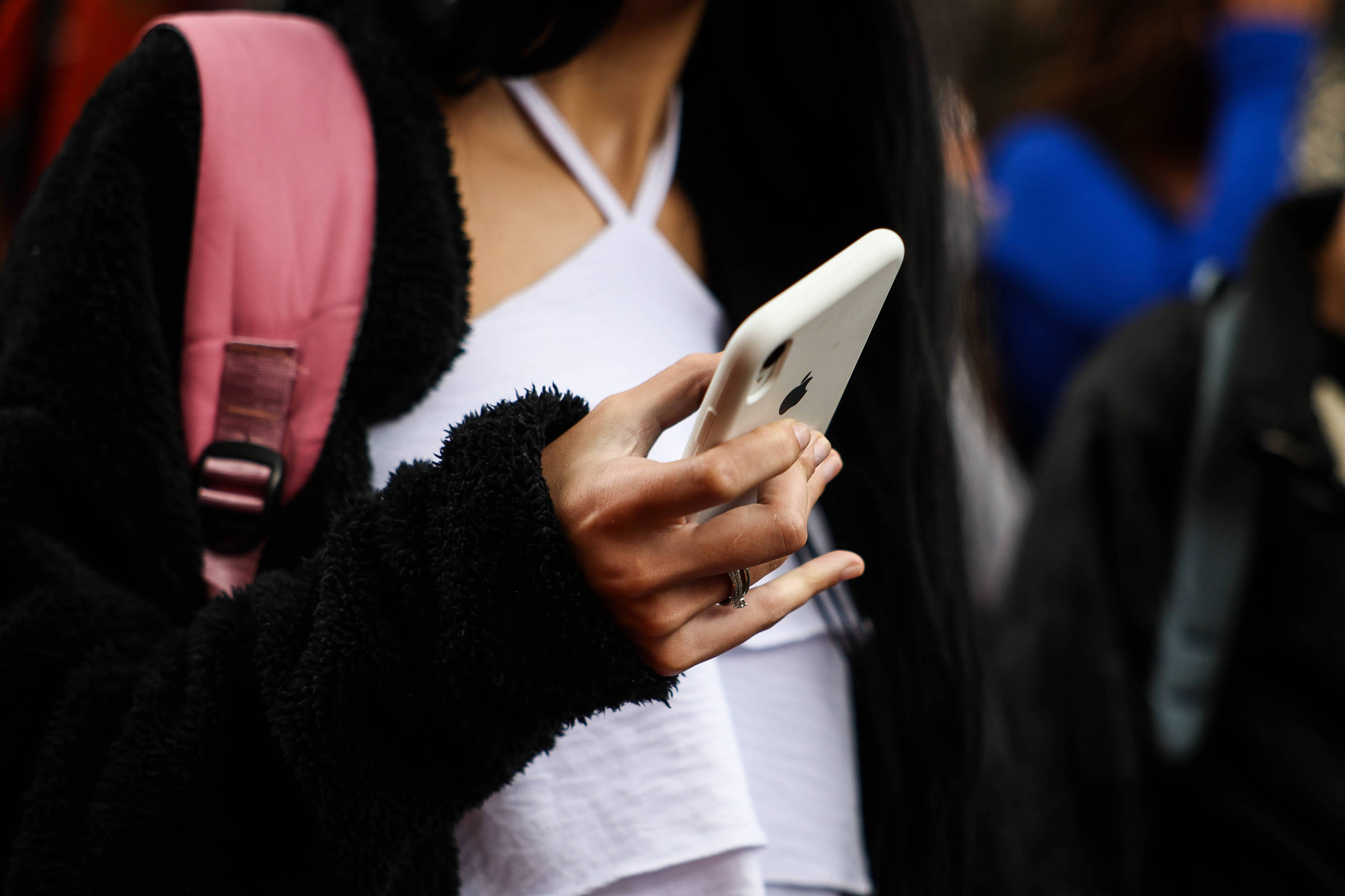 Adolescente usa celular na saída de escola estadual em São Paulo; algoritmos levam usuários a entrar em bolhas nas redes sociais (Foto: Zanone Fraissat - 3.fev.2025/Folhapress)