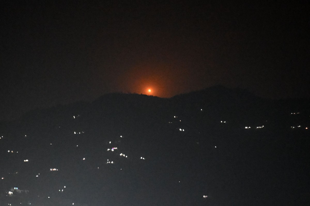Clarão é visto perto de montanha no distrito de Poonch, na região da Caxemira administrada pela Índia (Foto: Punit PARANJPE / AFP)