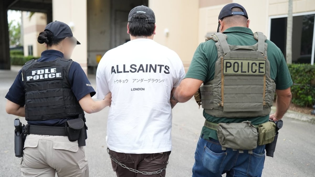 Agentes da polícia trasladam a um detido durante operação migratória em Miami, no dia 1 de maio de 2025. (Foto: EFE)