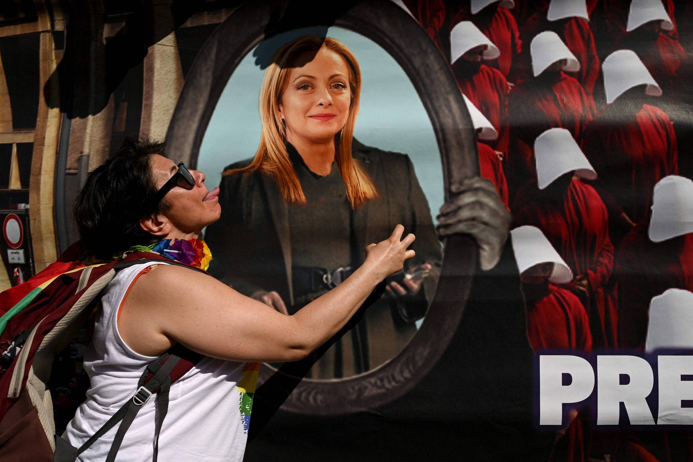 Participante da Parada do Orgulho LGBTQIA+ em Milão, na Itália, ao lado de imagem da primeira-ministra Giorgia Meloni (Foto: Gabriel Bouys/AFP)