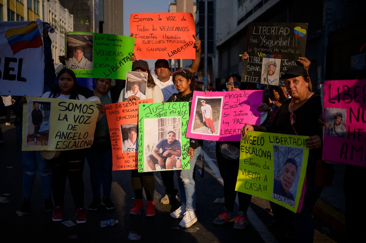 Familiares de migrantes venezuelanos deportados dos Estados Unidos para a prisão do Centro de Confinamento do Terrorismo em El Salvador marcham durante uma protesto para exigir sua liberação, em Caracas. (Foto: GABY ORAA/EL PAÍS)