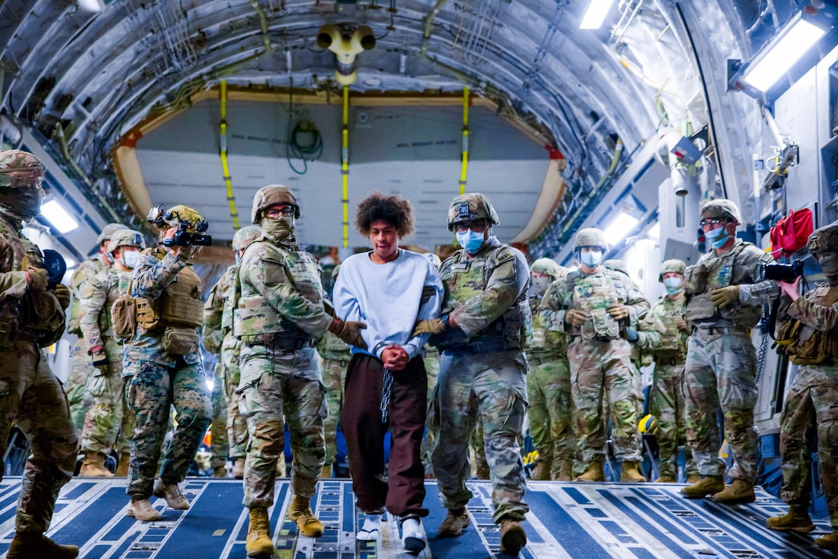 Militares dos Estados Unidos escoltam presuntos membros da pandilha venezolana Tren de Aragua durante sua deportação para El Salvador, em 31 de março. (Foto: GOVERNO DE EL SALVADOR via REUTERS)