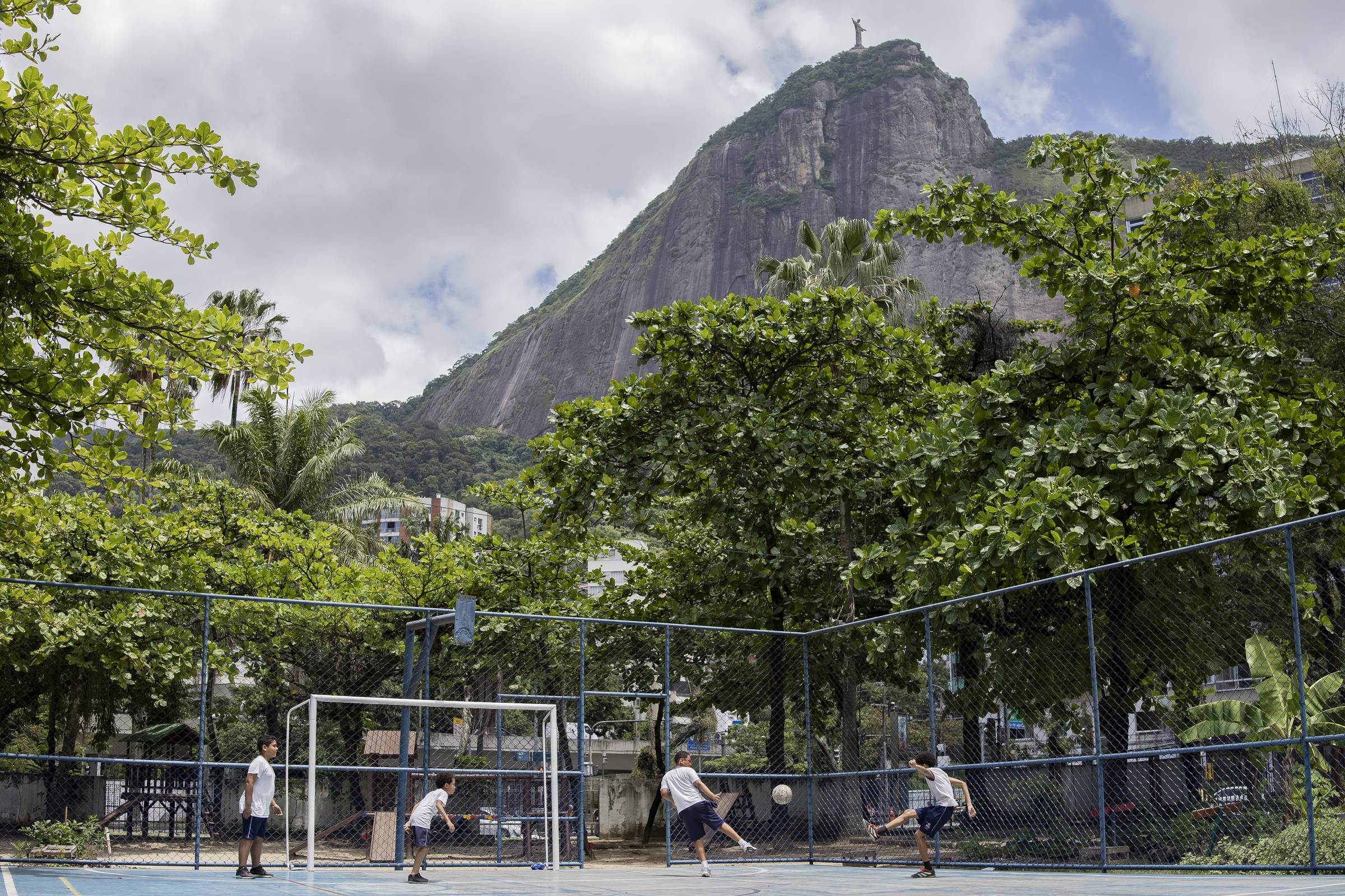 Crianças jogam bola em escola municipal no Rio; na cidade, as escolas têm implementado adaptações para enfrentar o calor extremo (Foto: Eduardo Anizelli - 12.dez.2024/Folhapress)