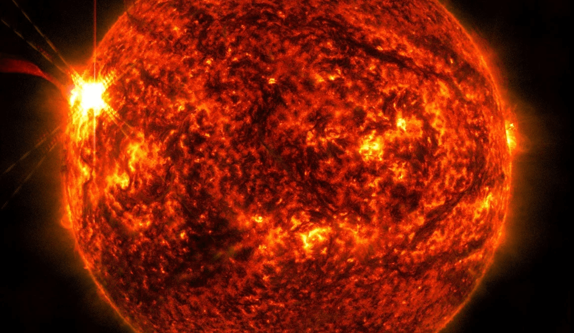 O Observatório de Dinâmica Solar da NASA capturou esta imagem de uma erupção solar (vista como o flash brilhante à esquerda) em 14 de maio. A imagem mostra um subconjunto de luz ultravioleta extrema que destaca o material extremamente quente nas erupções e é colorida de vermelho. (Foto: NASA)