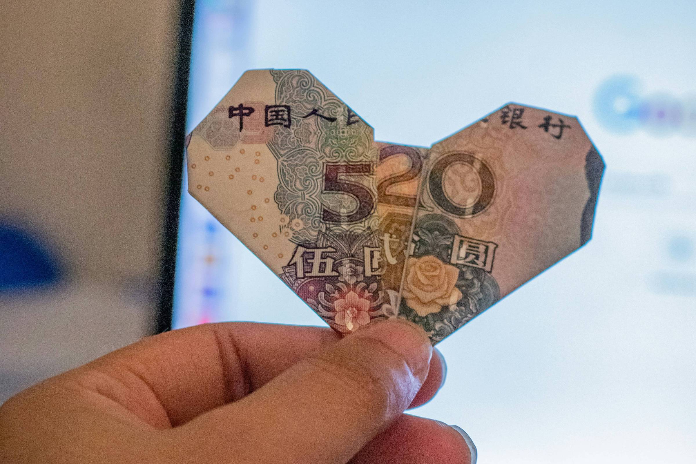 Dobradura de coração feita em nota (Foto: Mitchell Luo/Unsplash)