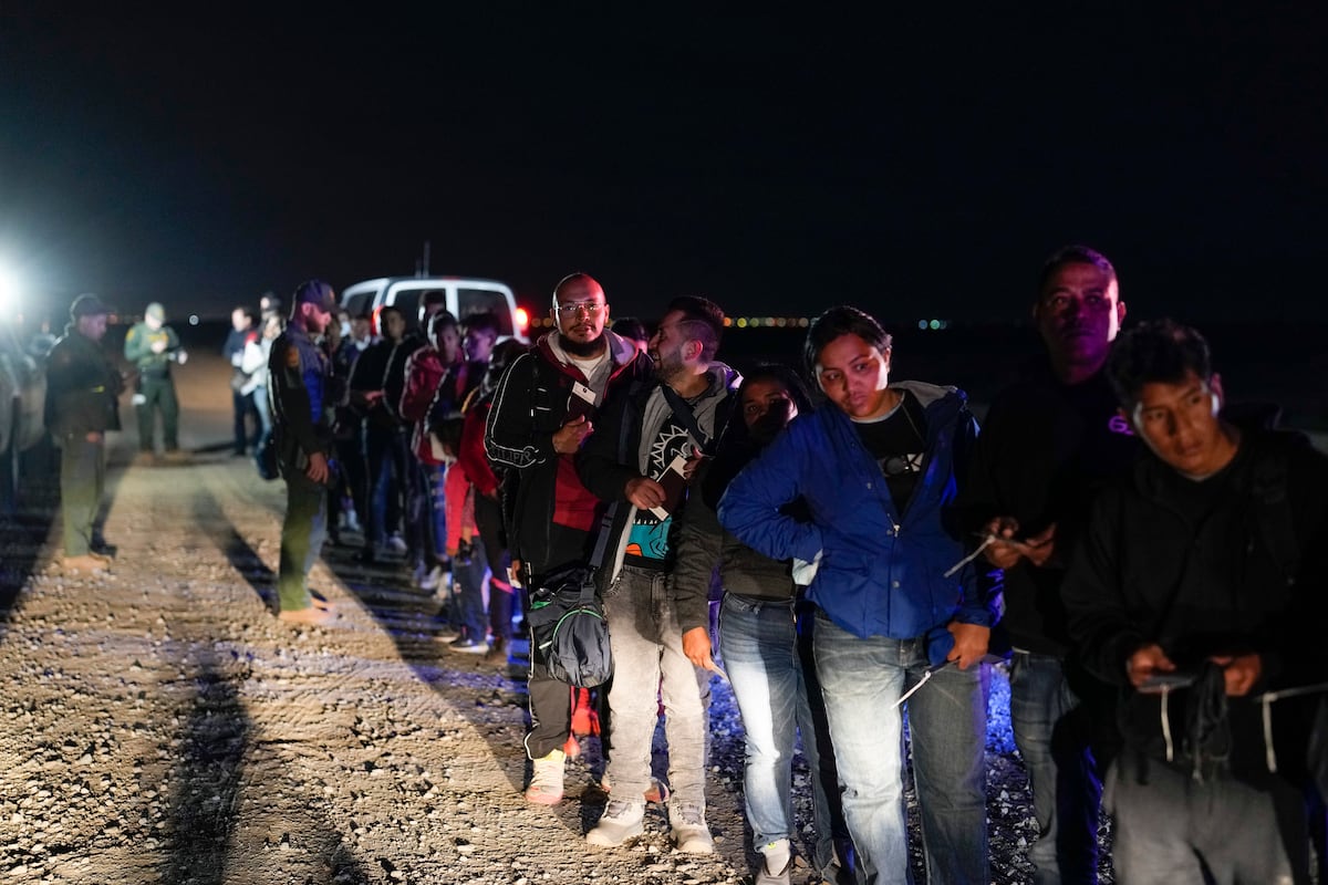Migrantes esperam ser processados para pedir asilo após ingressar nos Estados Unidos em Yuma, Arizona, em janeiro de 2023. (Foto: Gregory Bull/AP)