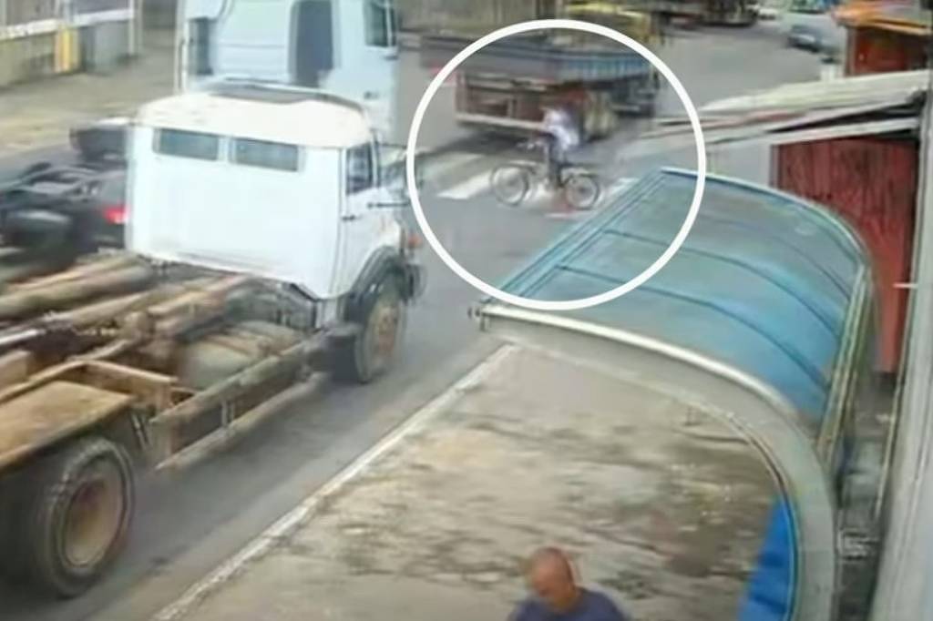 Momento em que o adolescente atravessa a faixa de pedestres; ele foi atropelado pelo caminhão branco à esquerda (Foto: Reprodução/TV Band)