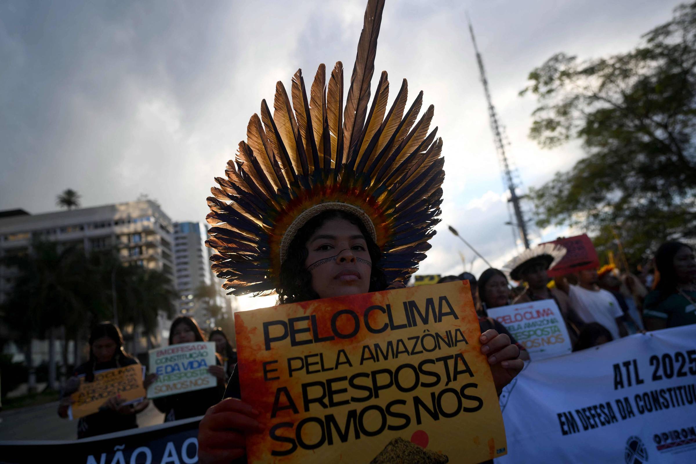 Mulher indígena pede maior participação contra a crise climática no Brasil durante protesto no Acampamento Terra Livre, em Brasília, nesta quinta (10) (Foto: Mauro Pimentel/AFP)