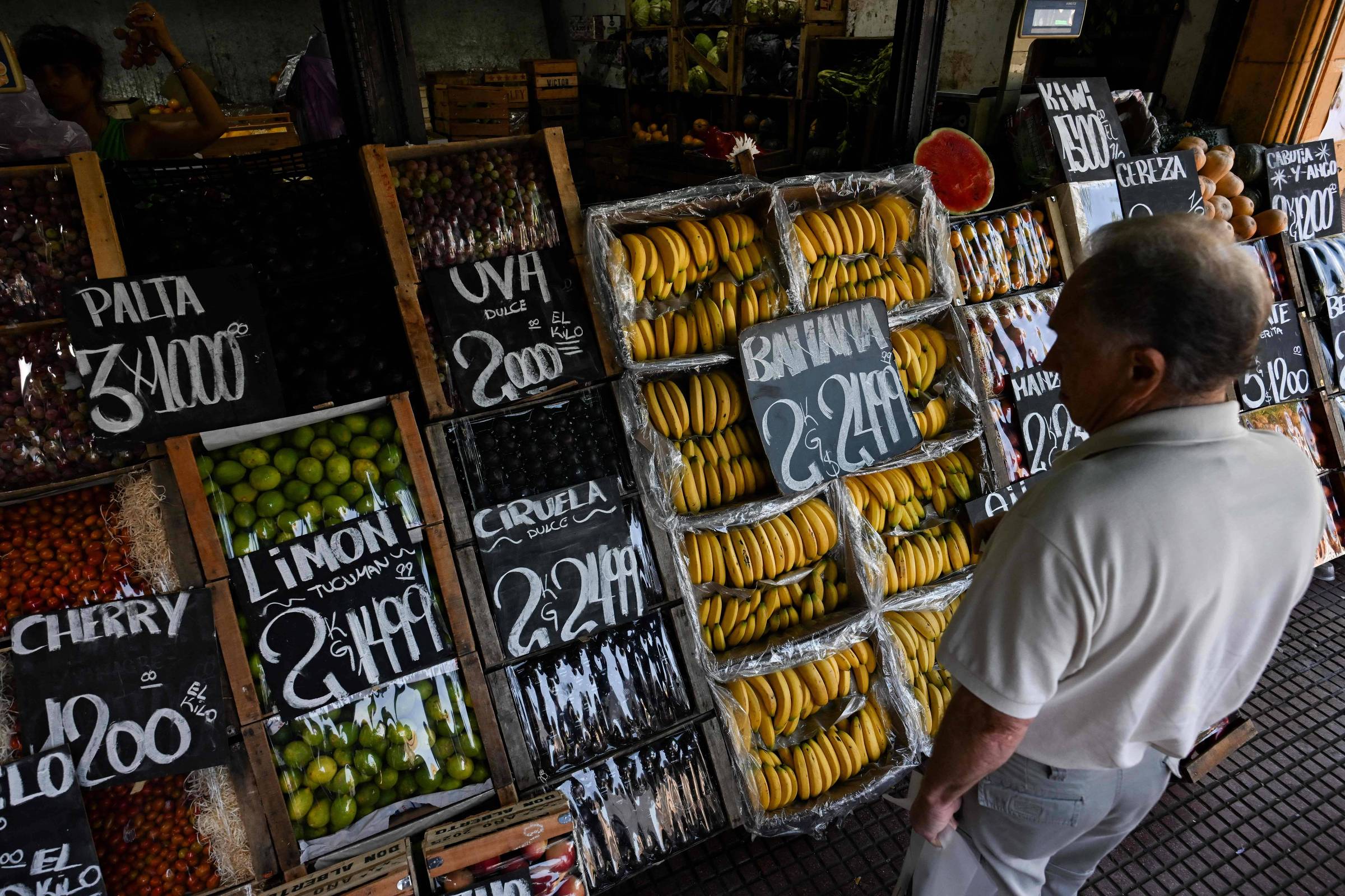 Consumidor observa preços de frutas e legumes em Buenos Aires (Foto: Luis Robayo/AFP)