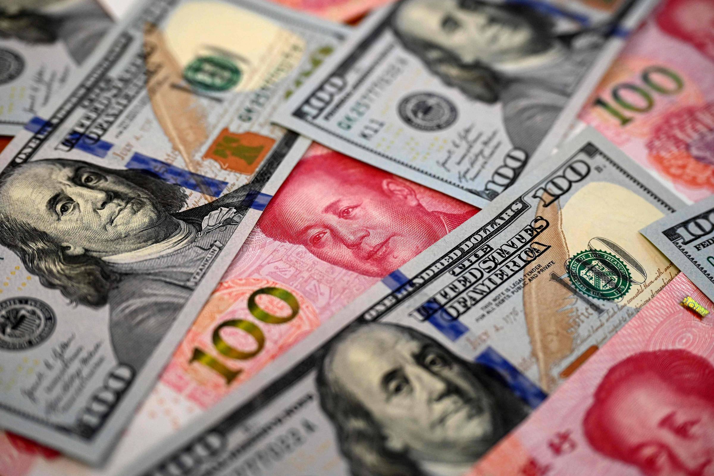 Cédulas de dólar e yuan; EUA e China disputam guerra tarifária (Foto: Jade Gao/AFP)