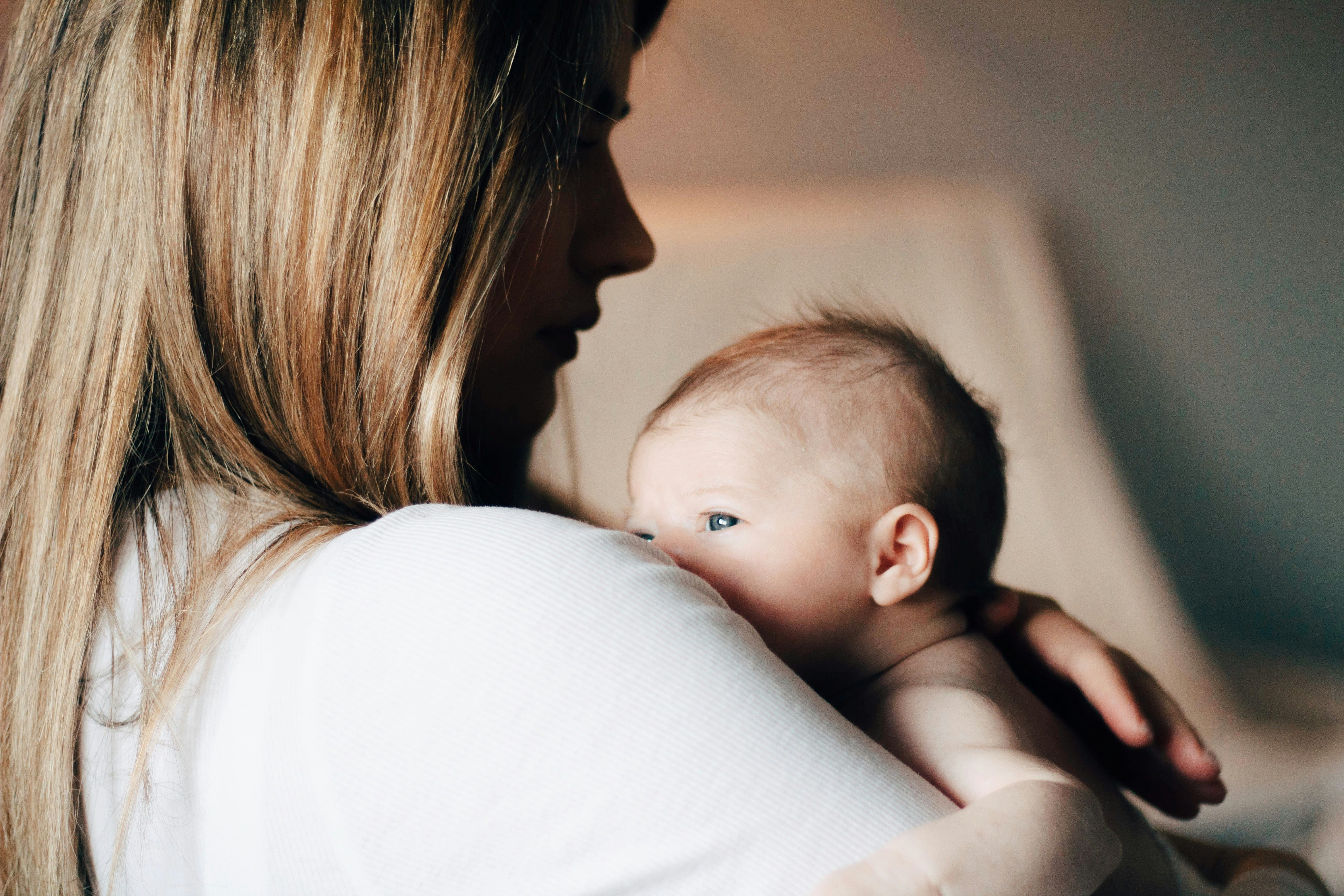 Mãe segura bebê (Foto: Unsplash)