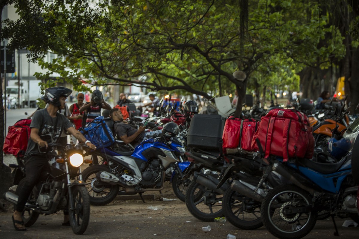 Entregadores descansam diante de shopping no Rio (Foto: Guito Moreto/Agência O GLOBO)