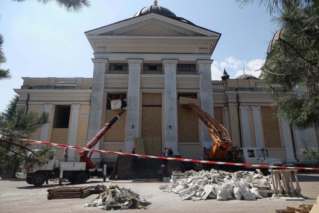 Cranes and workers board up the windows of the Transfiguration Cathedral damaged as a result of a missile strike in Odesa. (Foto: AFP via Getty Images)