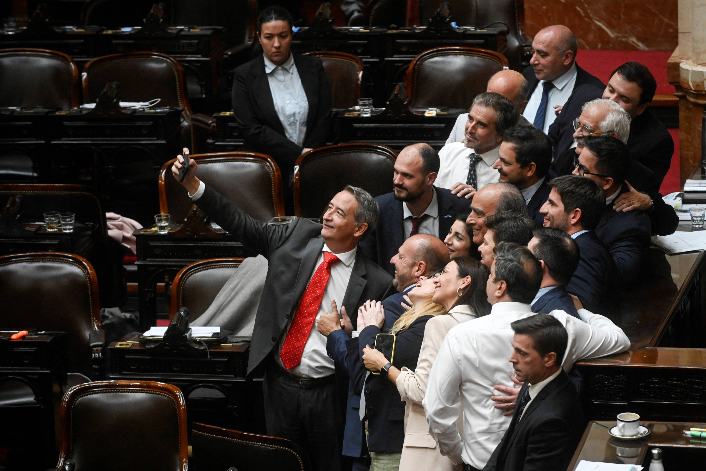 Deputados de A Liberdade Avança tiram uma selfie com o ministro Guillermo Francos, no dia em que uma comissão se reuniu para investigar o caso $Libra (Foto: Mariana Nedelcu/Reuters)