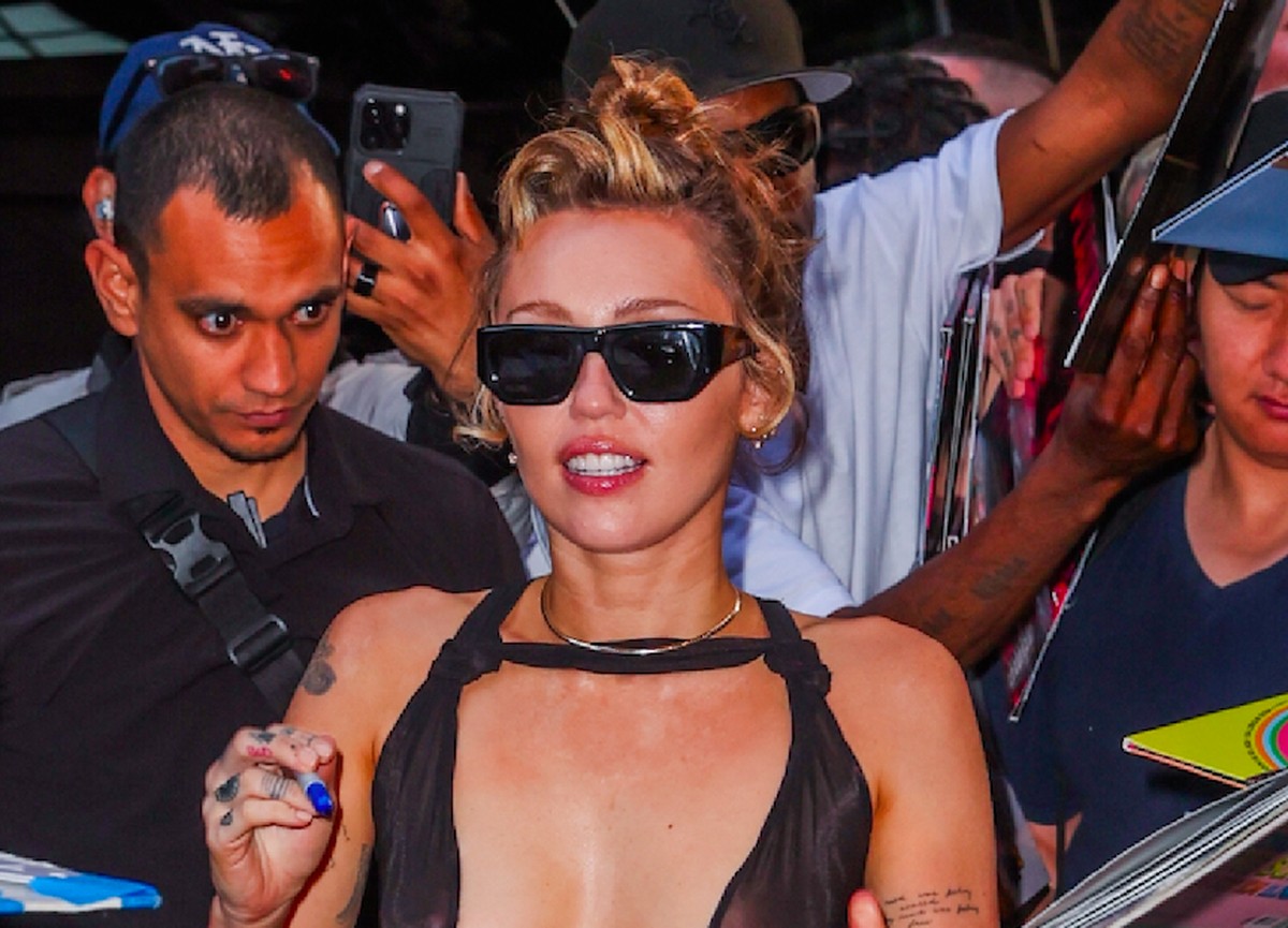 A cantora Miley Cyrus dando autógrafos para fãs que a aguardavam na entrada do hotel ocupado por ela em Nova York, em 4 de junho de 2025. (Foto: Getty Images)
