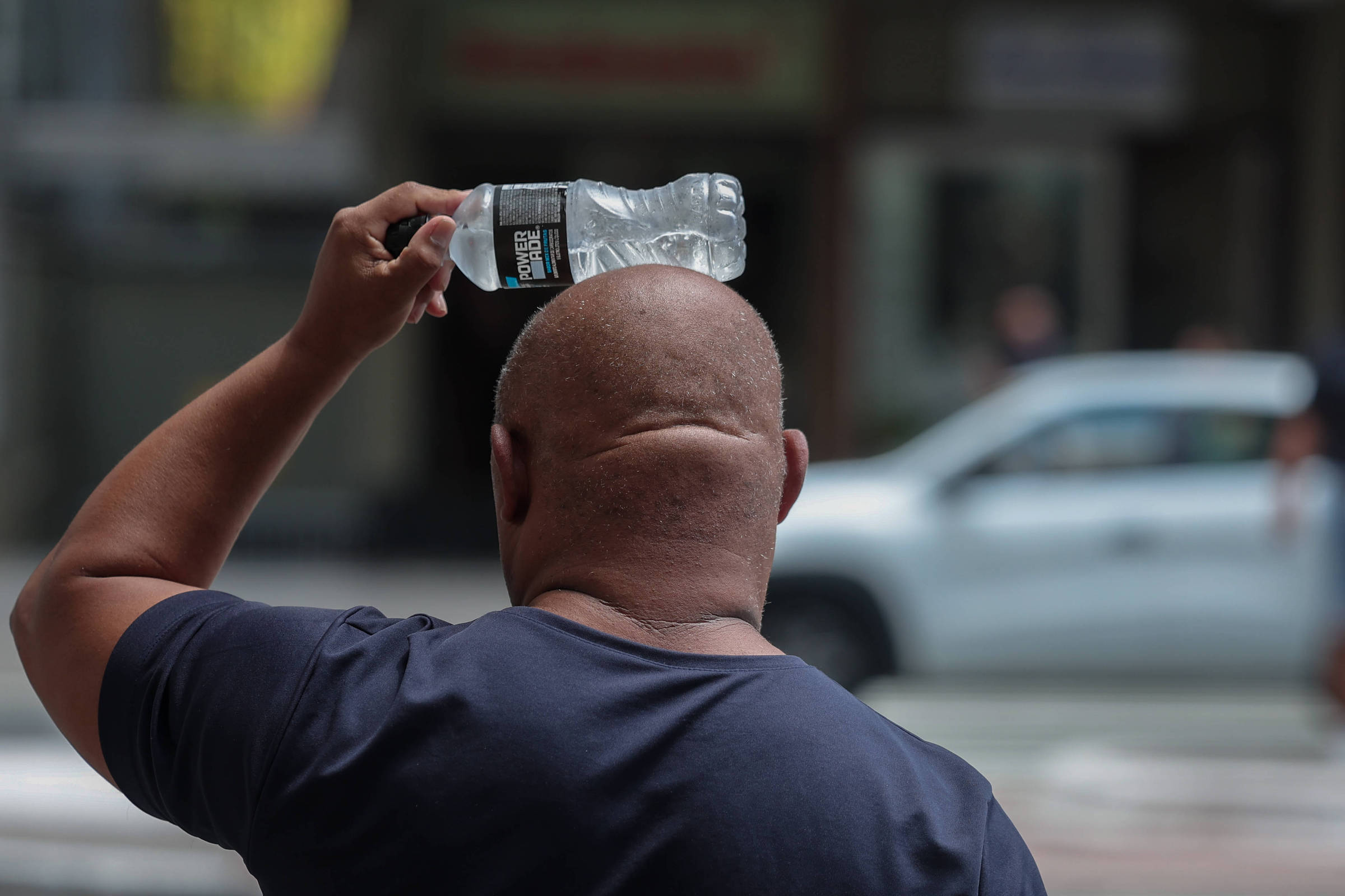Um homem tenta se refrescar com uma garrafa de água na cabeça na Avenida Paulista (Foto: Danilo Verpa - 18.fev.25/Folhapress)