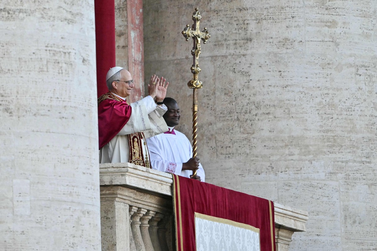 O recém-eleito Papa Leão XIV, Robert Francis Prevost, gesticula na varanda principal da galeria central da Basílica de São Pedro (Foto: Andrej ISAKOVIC / AFP)