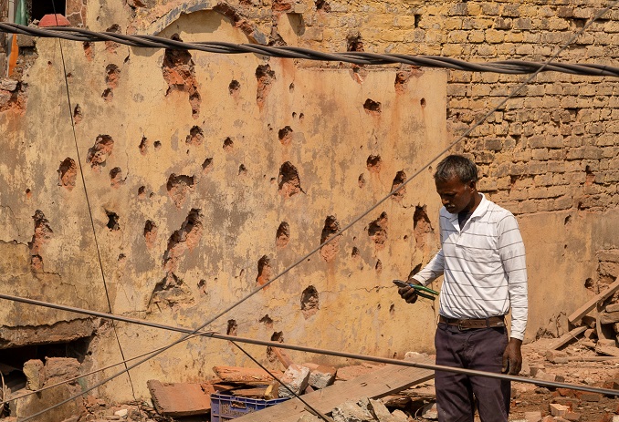 Um homem está em meio aos destroços no telhado de uma casa danificada, após a operação militar do Paquistão contra a Índia, em Rehari, Jammu, 10 de maio de 2025. (Foto: REUTERS/Adnan Abidi)