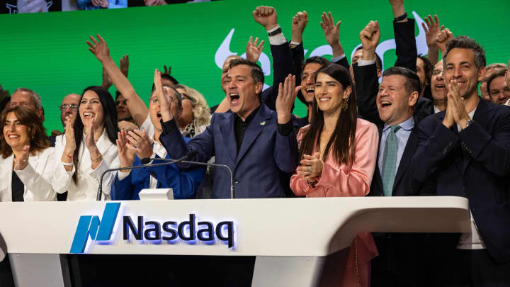 Yoni Assia, cofundador e diretor executivo da EToro Group Ltd., ao centro, e Ronen Assia, cofundador da EToro Group Ltd., à esquerda, tocam o sino de abertura durante a oferta pública inicial da empresa no Nasdaq MarketSite em Nova Iorque, Estados Unidos, na quinta-feira, quinze de maio de dois mil e vinte e cinco. (Foto: Yuki Iwamura | Bloomberg | Getty Images)