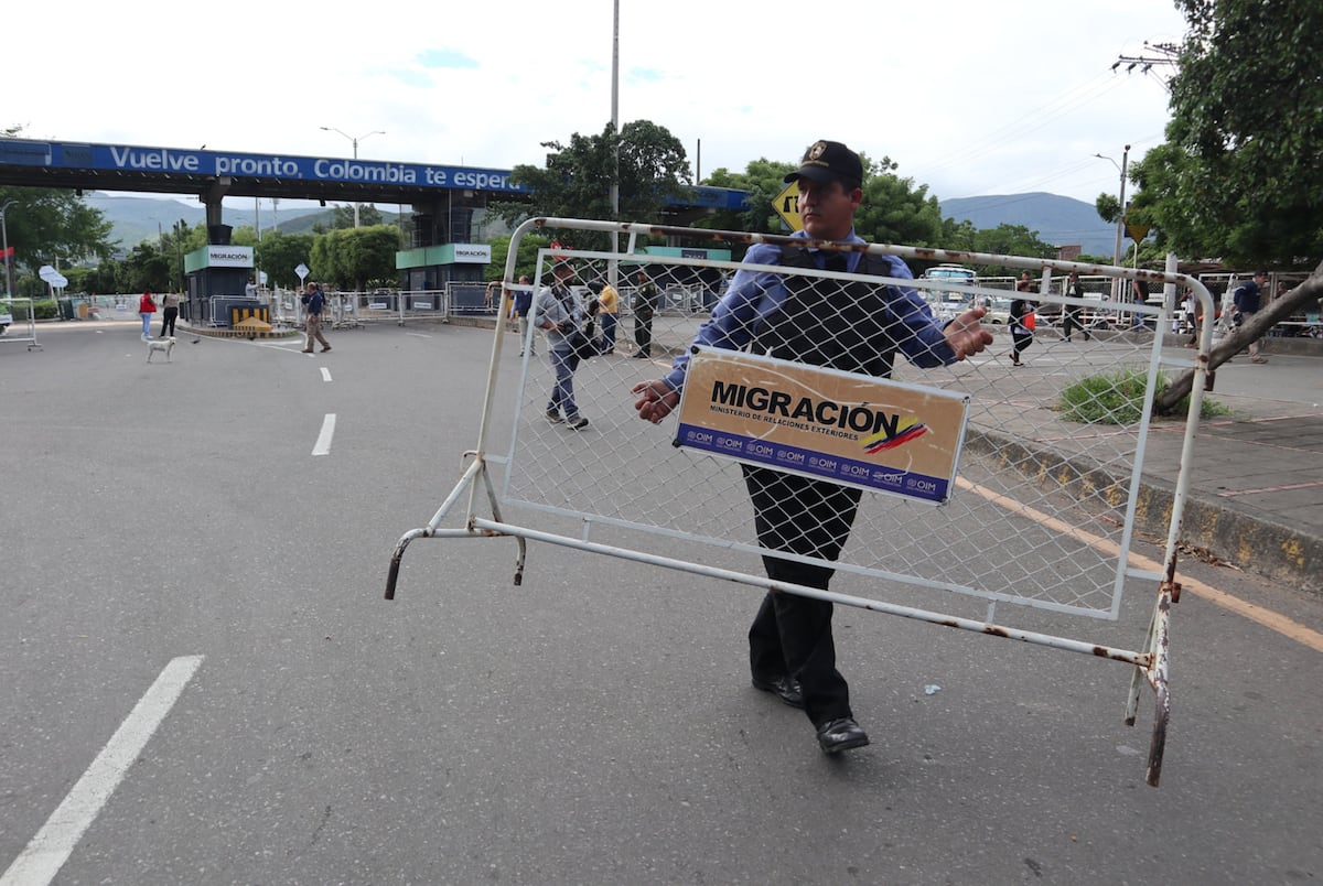 Um agente sostiene una valla de Migración Colombia el viernes en Cúcuta, por donde han salido millones de venezolanos. (Foto: Mario Caicedo - EFE)