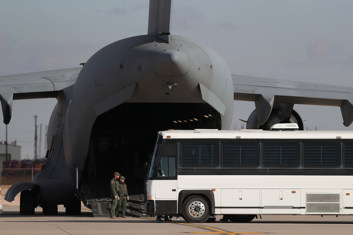 Uma aeronave militar espera a migrantes que abordan um ônibus em Fort Bliss, El Paso, Texas, no dia 30 de janeiro de 2025. (Foto: Christian Chavez/AP)