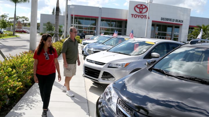 Um vendedor (à esquerda) mostra veículos a um comprador em uma concessionária da Toyota. (Foto: Getty Images)