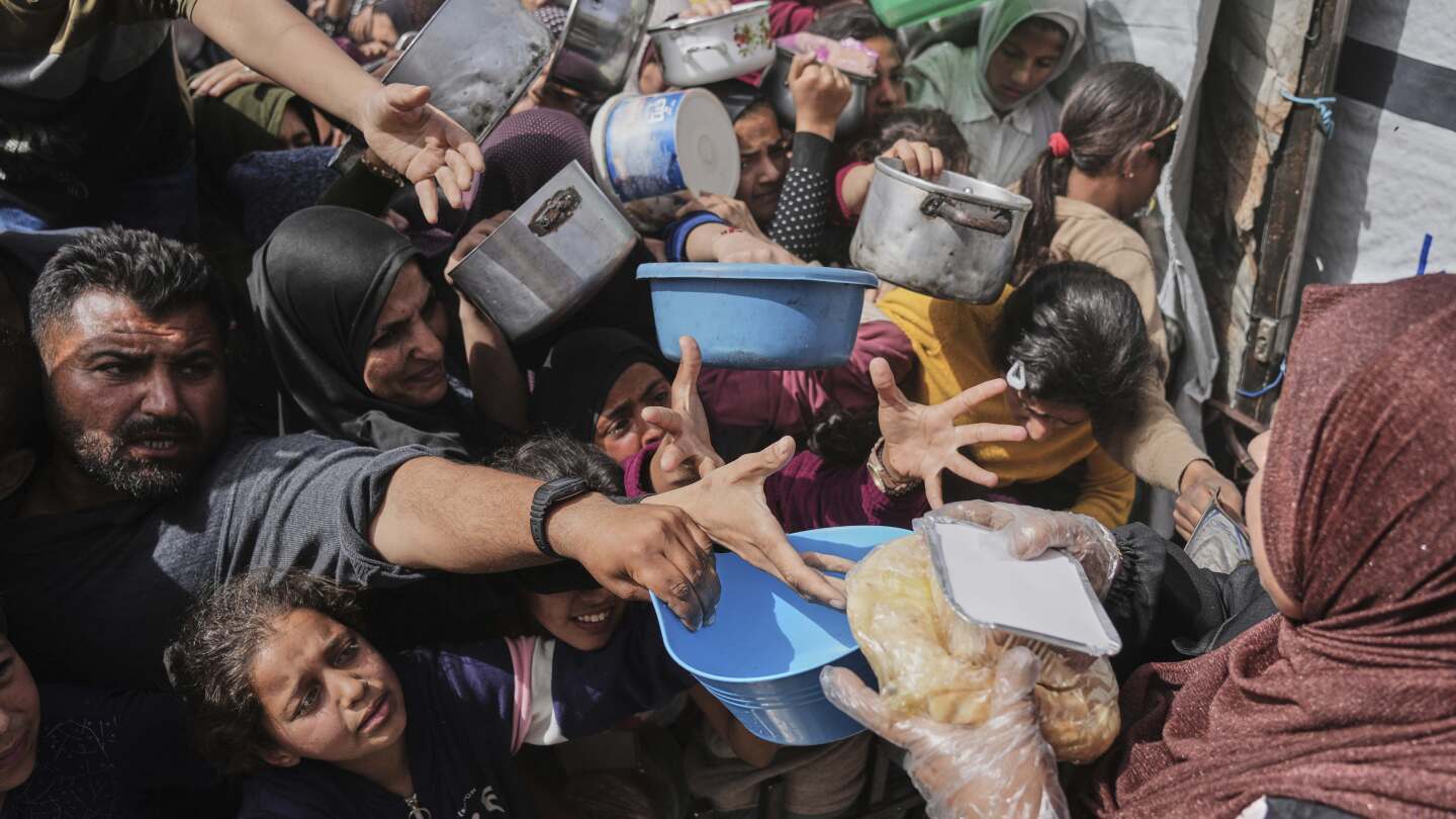 Palestinos aguardam para receber alimentos doados em um centro de distribuição em Beit Lahiya, no norte da Faixa de Gaza, na segunda-feira, 7 de abril de 2025. (Foto: Jehad Alshrafi/AP)
