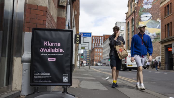 Pedestres passam por um anúncio da Klarna. (Foto: Daniel Harvey Gonzalez/In Pictures via Getty Images)