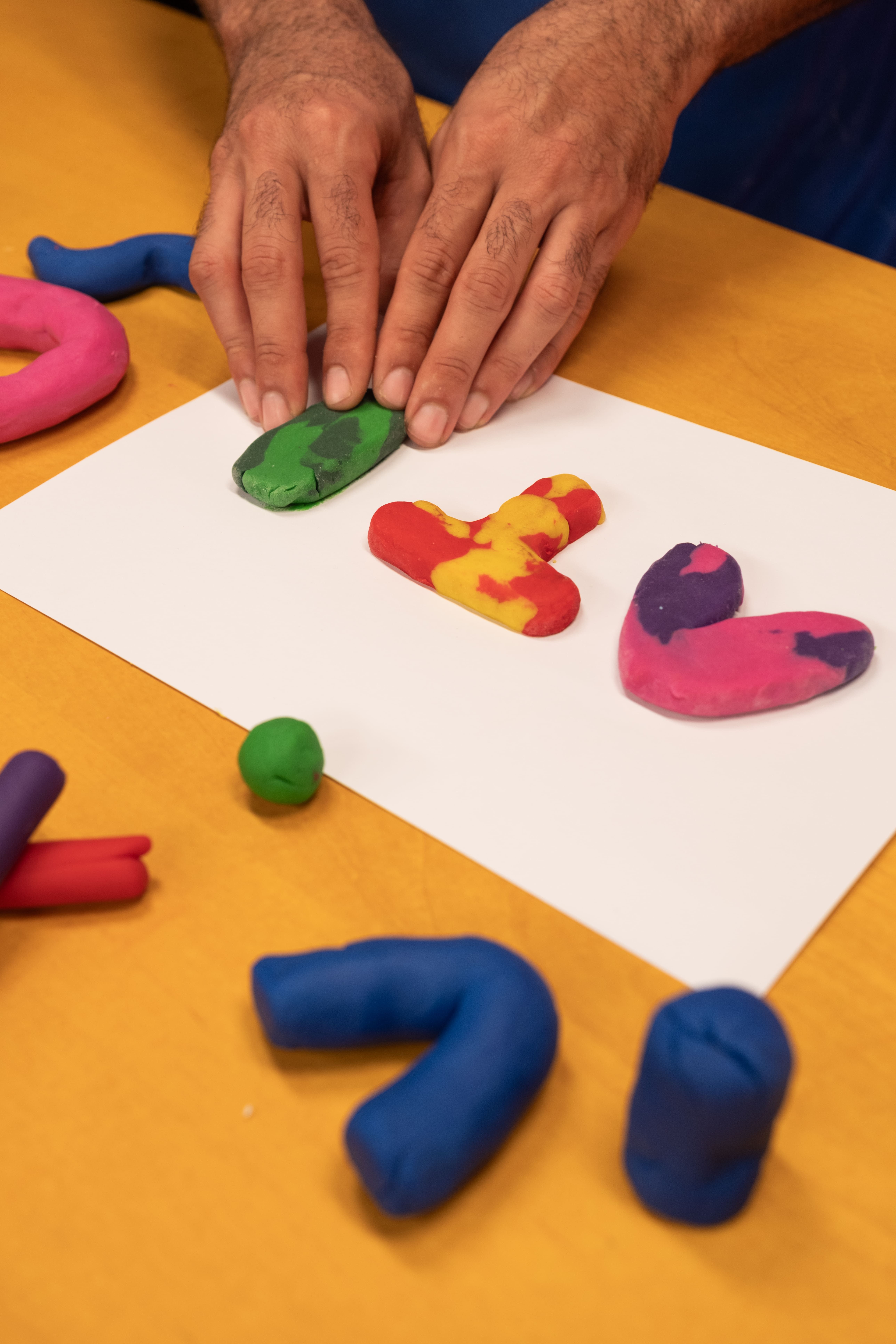 Na imagem tem massinhas coloridas na cor rosa, laranja e verde