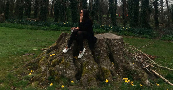 gisele sentada em um tronco de árvore