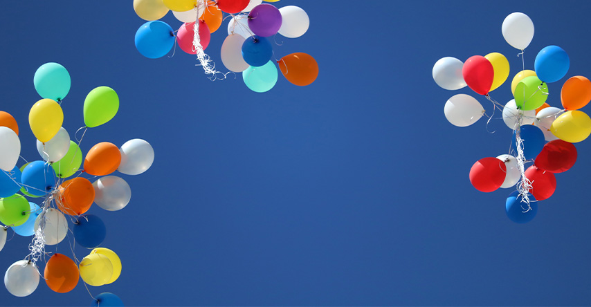 Balões de festa flutuando no céu limpo.