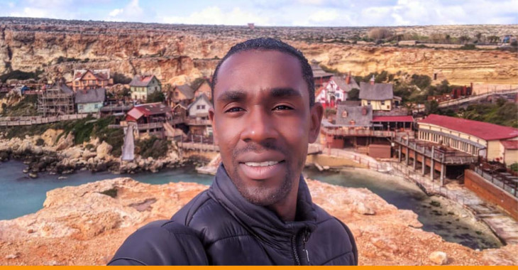 Homem em frente a vila do Popeye, em Malta