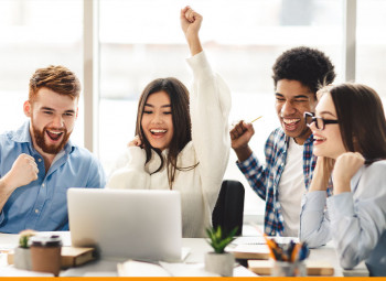 Jovens estudantes comemorando em roda de um mesa