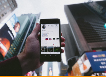 pessoa segurando um smartphone no meio da rua